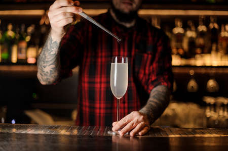 Barman putting a cherry into a French 75 cocktailの写真素材