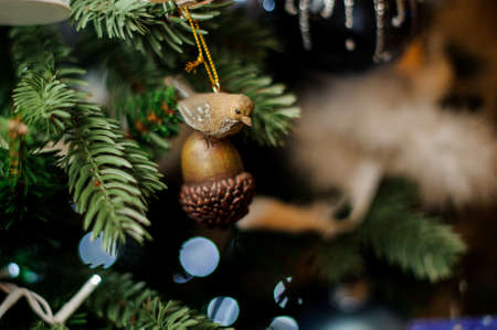 Background of evergreen fir tree with small brown acorn with bird toyの写真素材