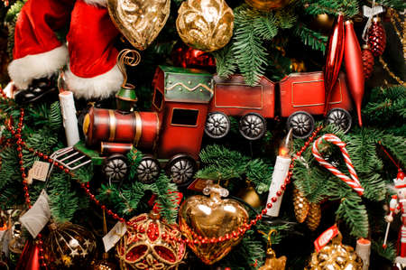 New year background of fir tree with red toy train and many beautiful christmas decorationの写真素材