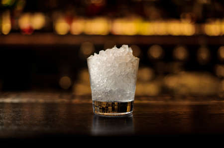 Cocktail glass of crushed ice standing on the bar counterの写真素材