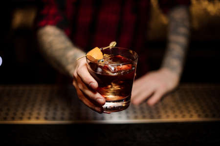 Professional bartender serving a delicious Godfather cocktailの写真素材
