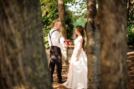 Hipster bride and groom walking in the forestの写真素材