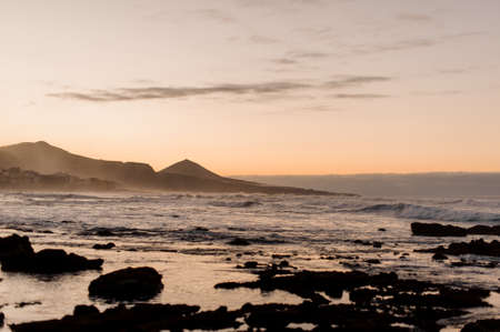 Sea coast and mountains in the background in the eveningの写真素材