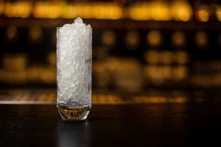 High glass with ice cubes on the bar counter of restaurantの写真素材