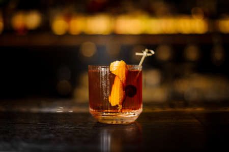 Glass of a Old Fashioned cocktail on the wooden bar counterの写真素材