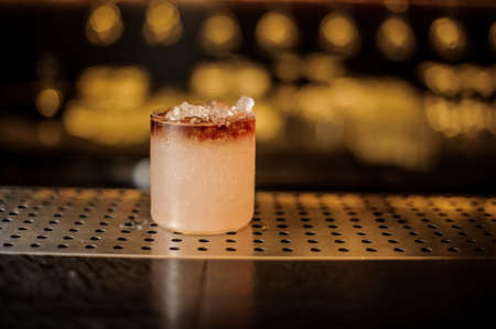 Elegant cocktail glass filled with tasty sweet alcoholic drink with iceの写真素材