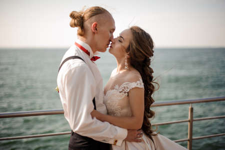 Just married boy and girl kissing each other on the pier on the lakeの写真素材