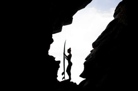 Silhouette side view girl in the swimsuit standing with the surfの写真素材