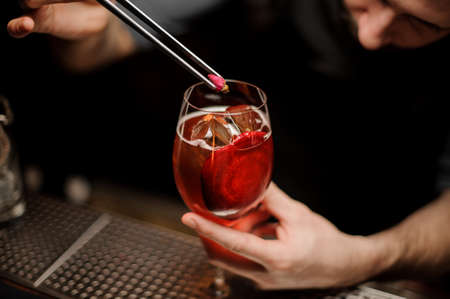 Bartender adding to a delicious cocktail decor of the little rose budの写真素材