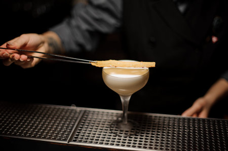 Bartender pours an alcohol cocktail in glass