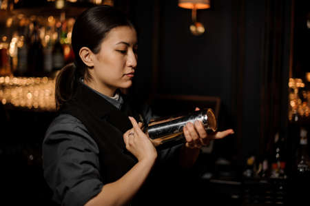 Bartender pours an alcohol cocktail in glassの写真素材