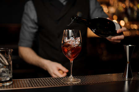 Bartender adds sparkling wine in cocktail on a bar counterの写真素材