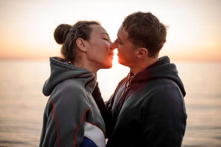 Young romantic couple stand opposite each other kissingの写真素材