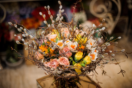 Unusual bouquet of white, pink and yellow flowers decorated with willow branchesの写真素材