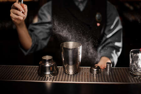 Bartender pours cocktail with shaker and sprayerの写真素材
