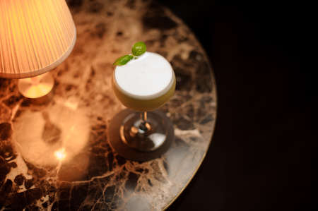 Alcohol cocktail with mint on a table with lampの写真素材