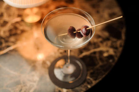 Close-up of alcohol cocktail with olives on the tableの写真素材