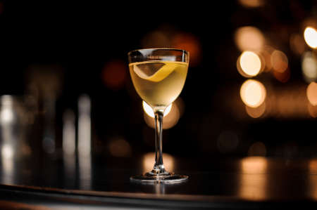 Close-up of the alcohol cocktail with lemon rind on counterの写真素材