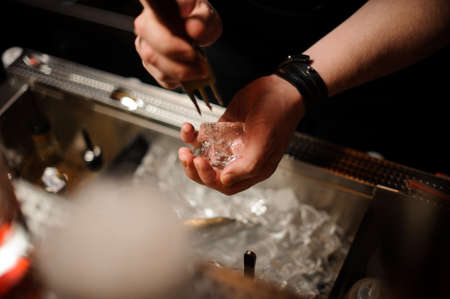 Close-up of bartender crushing ice with ice crusherの写真素材