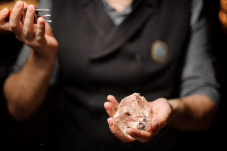 Close shot of bartender holding ice with ice crusher