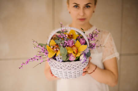 Woman holds a small basket with flowersの写真素材