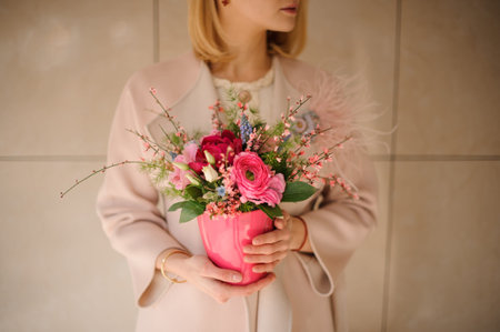Young woman holds bouquet in flower potの写真素材