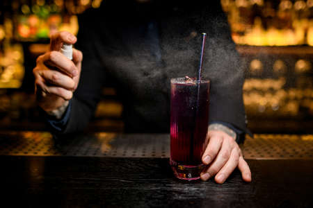Close-up of bartender spraying on alcohol cocktailの写真素材