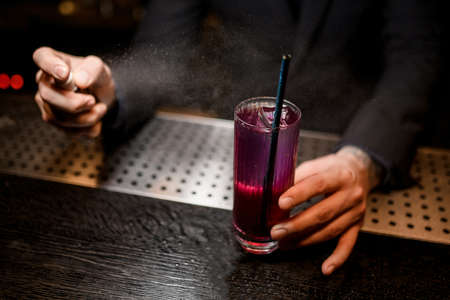 Close shot of bartender spraying to alcohol cocktailの写真素材