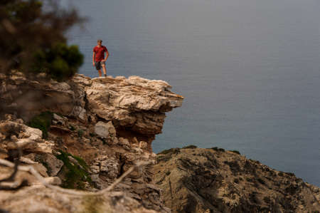 Man standing on the rock near the sea waterの写真素材