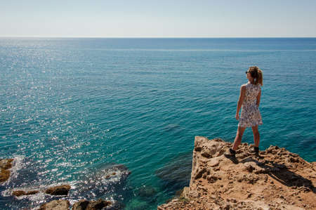 Young girl standing on the rock in dressの写真素材