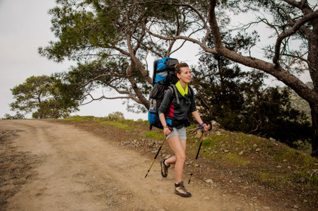 Woman walking on the path with hiking backpack