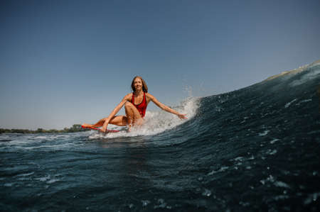 Woman with loose hair surfs in a seaの写真素材