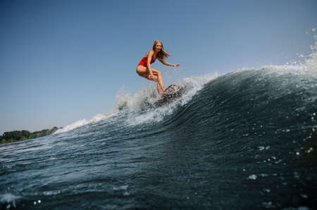 Woman with loose hair surfs in seaの写真素材