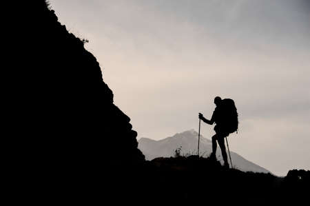 Silhouette of female hiker walking on mountainの写真素材