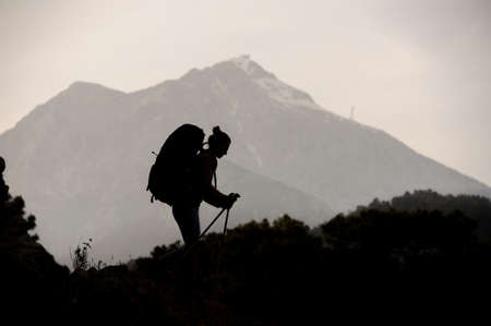 Silhouette of female hiker travelling on mountainの写真素材