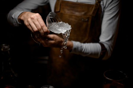 Male bartender holding a cocktail glass full of crushed ice