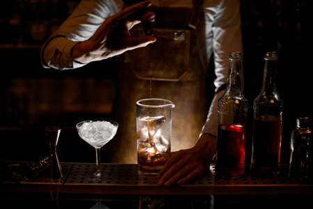 Bartender pouring an essence from the little glass bottleの写真素材