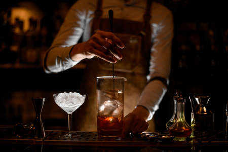 Bartender stirring a cocktail in the measuring glass cupの写真素材