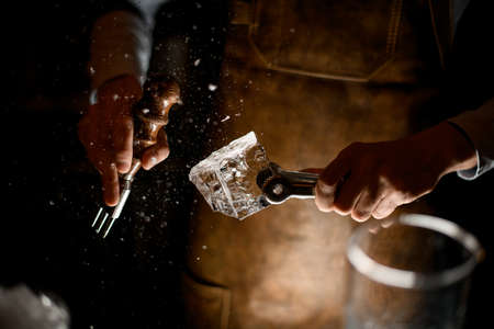 Bartender in leather apron making a crushed with a special forkの写真素材