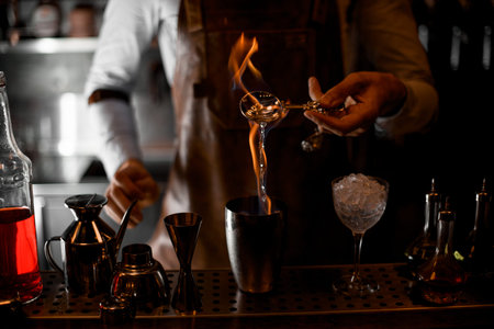 Bartender firing up alcohol in bar spoon