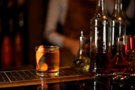 Glass with a whiskey, ice and zestの写真素材