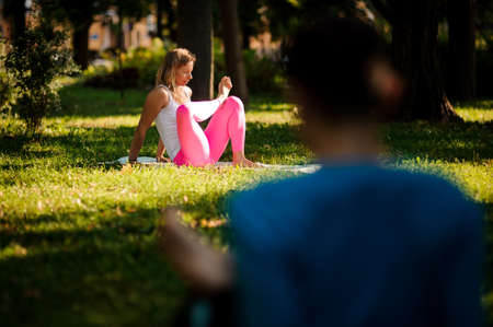Women in sportsuits practice different yoga poses in the parkの写真素材