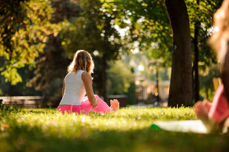 Woman in sportsuit practice different yoga poses in the parkの写真素材