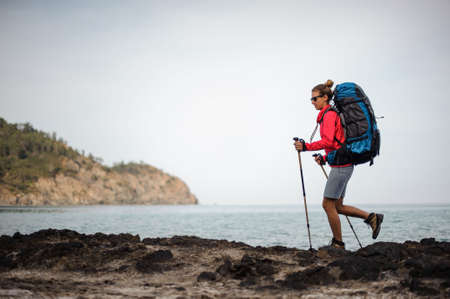 Female traveller in sunglasses walking near the seaの写真素材