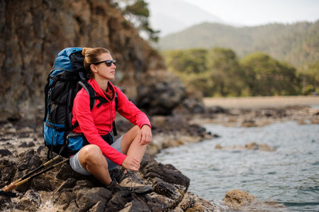Female traveller sitting in front of cliffs