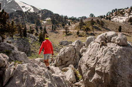 Female tourist with hiking equipment among stonesの写真素材
