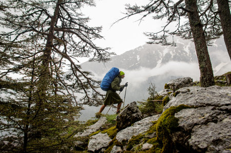 Female hiker goes up to top of the mountain