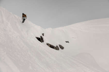 Paralympic snowboarder jumping down the white snow covered hillの写真素材