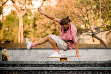 Man balancing squat on the balance board on the concrete steps in the parkの写真素材