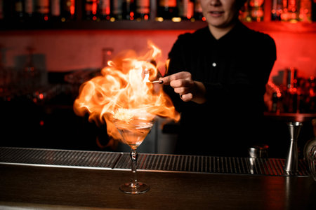 Bartender firing up alcohol cocktail on counter